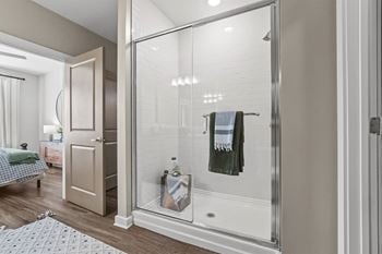 A bathroom with a glass shower door and a towel hanging on it.